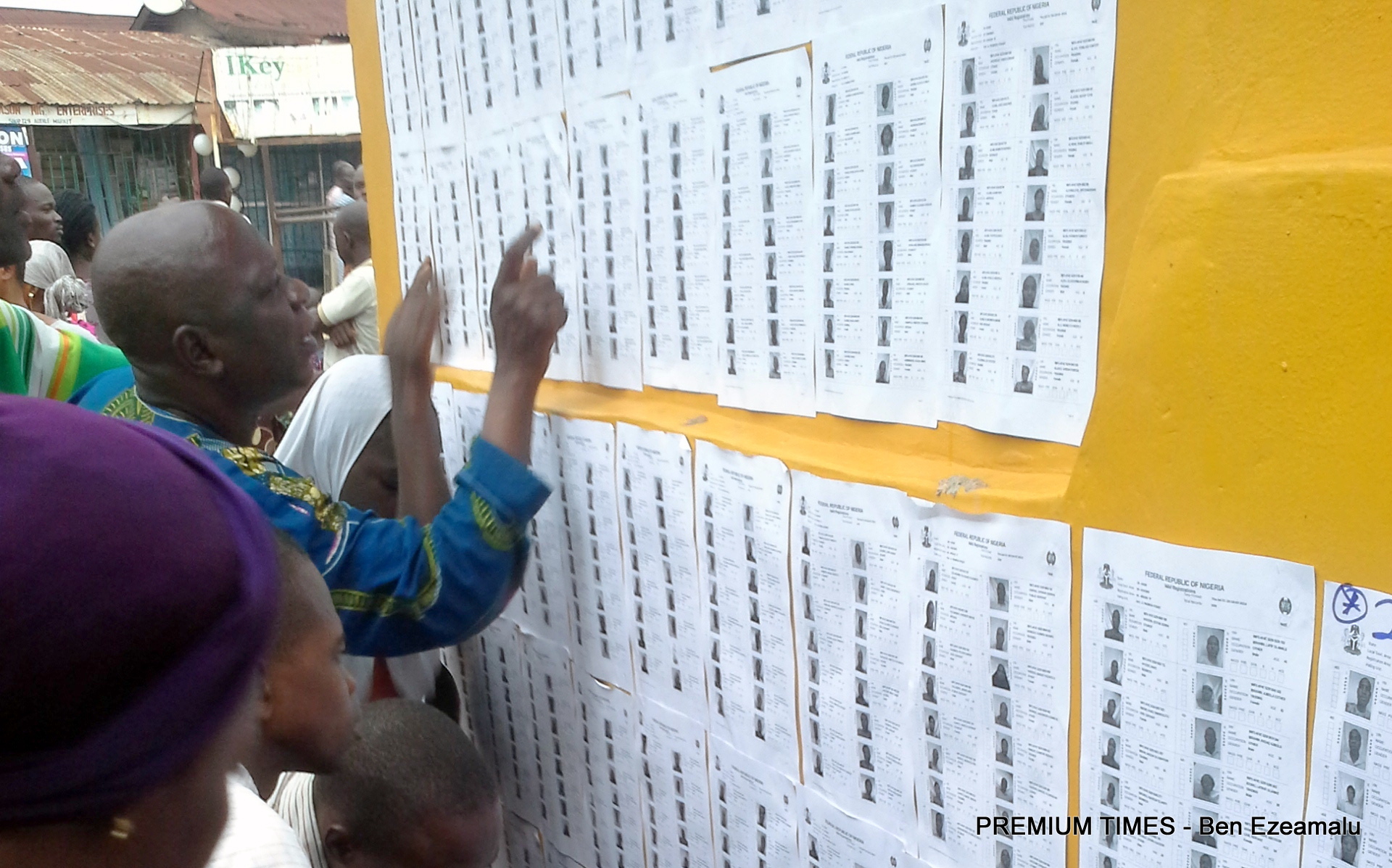 Osun election: voters crosschecking their names on the voters' register pasted on the wall