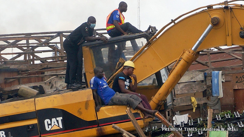 Nigerian Police Force officer rides on excavator on morning of 19 Sept 2015