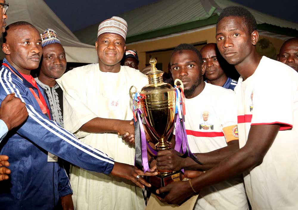 Speaker, House of Representatives, Rt. Hon. Yakubu Dogara presenting a Trophy  to the Captain of the Winning Team, Kabir  Ibrahim ( middle)  from 3sc Football club, Bauchi, at  the finals of Dogara Unity Cup Football competition sponsored by him in Bogoro LGA, Bauchi State on Friday 29th December,2017.