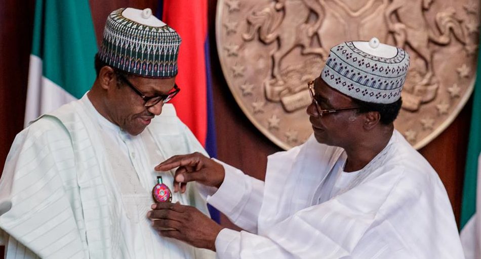 Chairman, Nigerian Legion, retired Brig.-Gen. Adakole Akpa decorating President Muhammadu Buhari with the 2019 Armed Forces Remembrance Day Emblem during the launch of the Appeal Fund at the Presidential Villa in Abuja on Wednesday