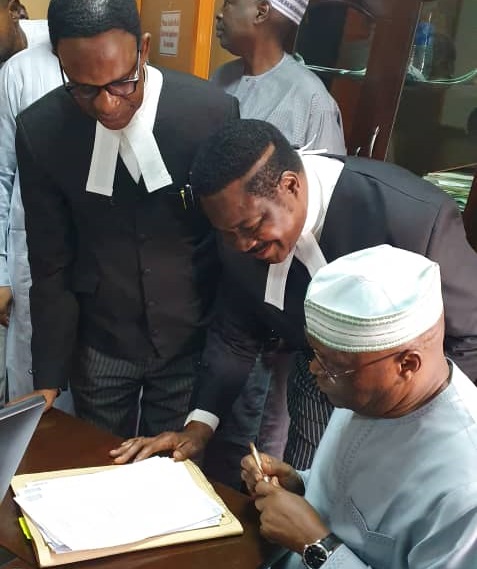 Atiku Abubakar sign his deposition in support of a N2.5 billion libel suit against an aide to President Muhammadu Buhari