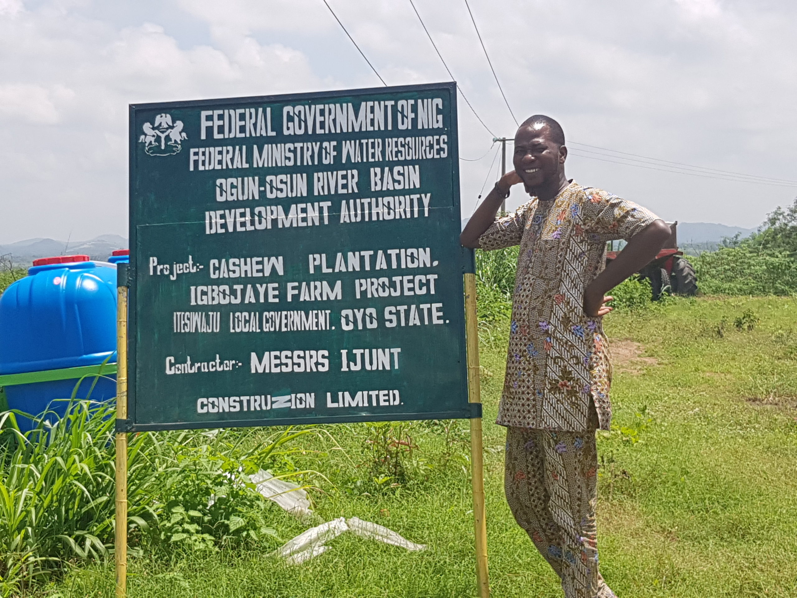 Mr. Akinola standing by the signboard indicating the location of the dam site