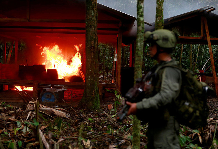 An anti-narcotics policeman stands guard after burning a cocaine lab in a rural area of Guaviare state, Colombia, on August 2, 2016. [Credit: REUTERS/John Vizcaino/File Photo]