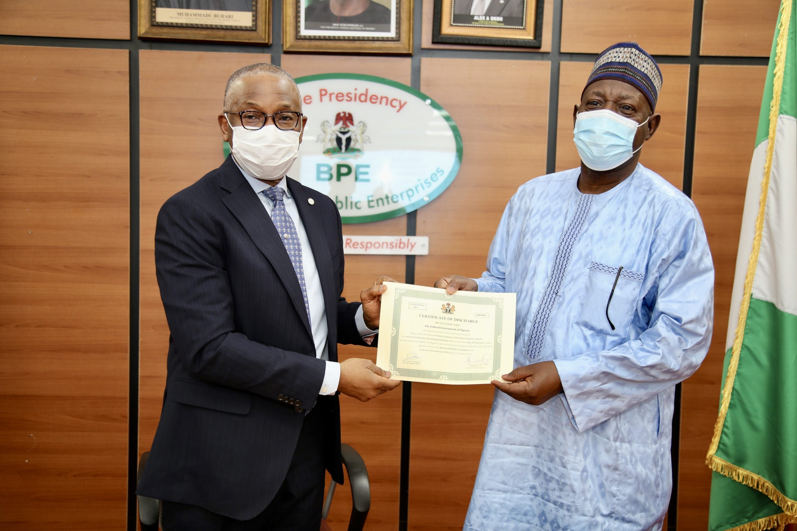 The Rep. of Cement Company of Northern Nigeria (CCNN) Sokoto, Mr. Sada Suleiman (r) displays the company’s discharge certificate after presentation by the Director General of the Bureau of Enterprises (BPE), Mr. Alex A. Okoh in Abuja.