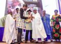 Former President Olusegun Obasanjo presenting the award to Agema, who received it on Oriogun's behalf.