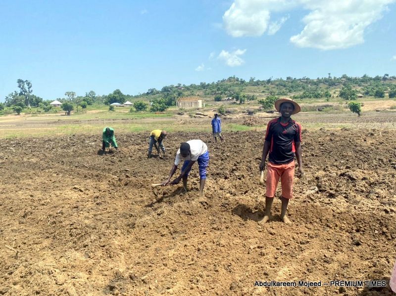 Farmers tilling and preparing destroyed farmland for the dry season farming