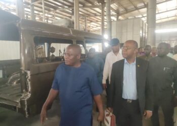 Jamaican High Commissioner to Nigeria, Esmond Reid, wearing suit, on a a tour of the IVM plant in Anambra