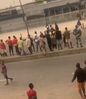A screenshot of a video where some hoodlums were throwing stones at First bank
