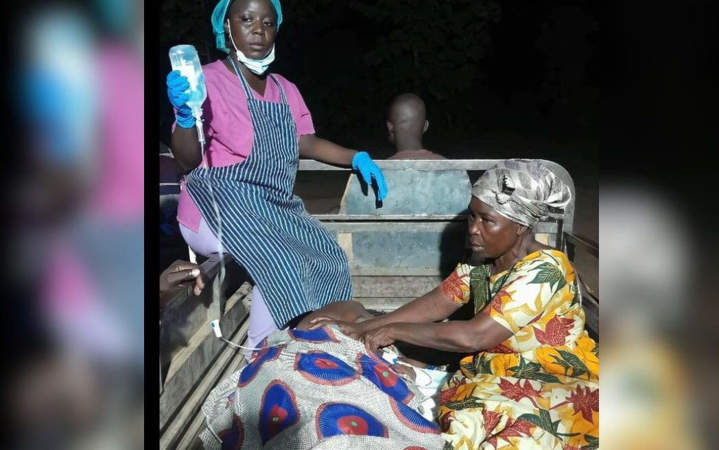 Image of patient on drip in an open vehicle, not from Nigeria